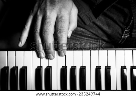 The man playing piano.One hand photographed. Black and white.