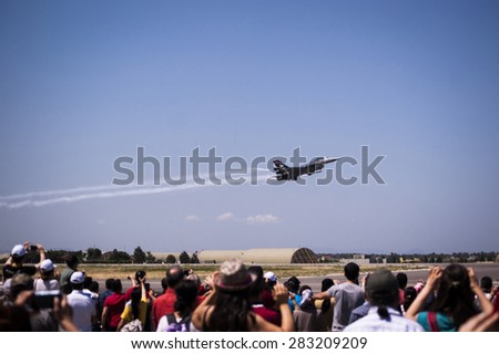Izmir, Turkey - May 31, 2015: Solo Turk war plane on a demonstration flight. Crowded people is watching the flight. Turkihs airforce 104. anniversary demonstration flight.