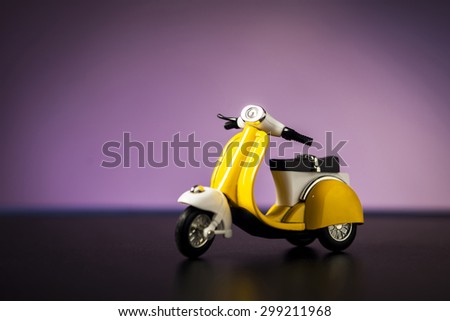 Yellow toy motorcycle on a purple background.