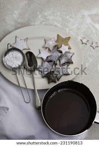 Homemade Christmas cookies with a dish of melted chocolate viewed from above
