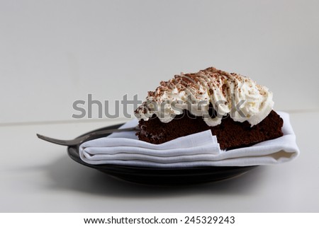 Slice of homemade Belgium chocolate cake with whipped cream on the top