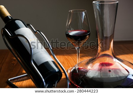 Carafe, bottle and the glass of red wine on the table