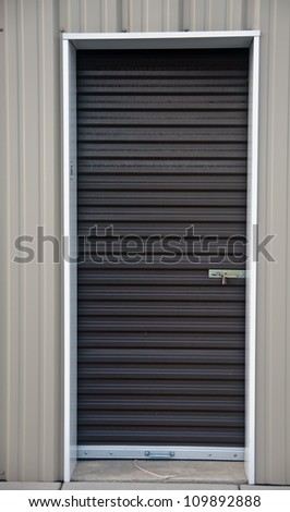 Brown metal door with padlock, of an outdoor storage unit