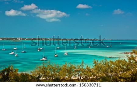 many sailboats and power boats anchored in crystal clear turquoise waters of the bahamas.  copy space available.