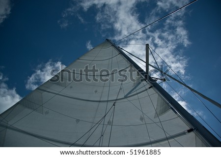 looking up the mast with main sail set on a sailboat with white sail