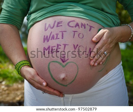 belly of pregnant woman, with hands holding belly