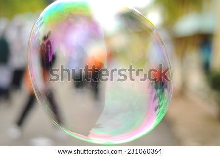 Blur image of children playing giant bubbles.
