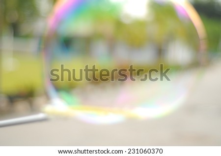 Blur image of children playing giant bubbles.