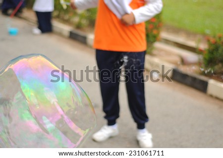 Blur image of children playing with giant bubble