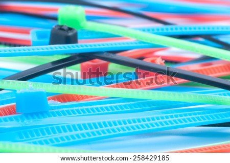 self-locked plastic zip cable ties in different colors over white background
