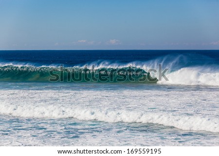 Ocean Wave Wall Ocean wave upright crashing surging onto shallow reefs with a long blue wall