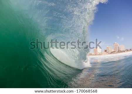 Hollow Ocean Wave Blue Sky Clean ocean wave surging and crashing towards shallow sandbars and shoreline
