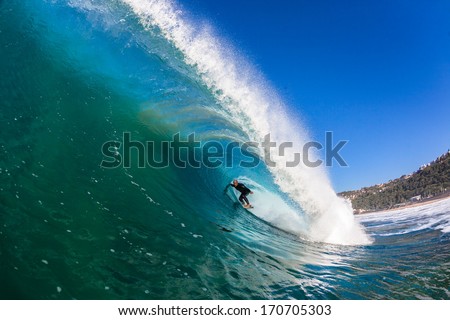 Surfer Inside Hollow Wave Surfer rides inside a good size hollow tubing wave of shallow reefs.