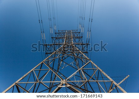 Power Lines Tower Electrical power cable lines attached to steel tower in blue sky