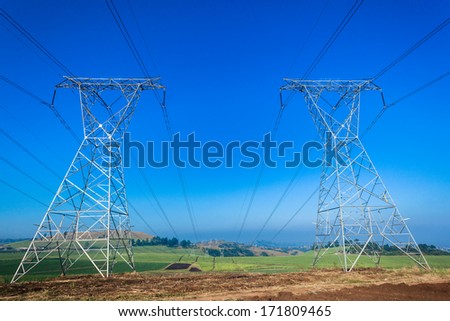 Electrical Power Lines Towers Electrical power line cables suspended from steel towers transporting energy supply to consumers in homes and economy.