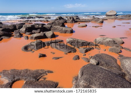 Pollution Industrial Oceans Industrial chemical liquid pollution pours onto ocean coastline rocks and ocean blue sea  waters form storm drains.