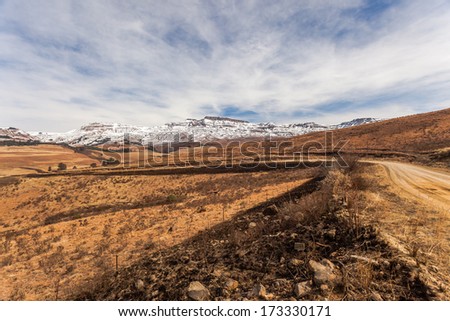 Mountains Dry Snow Contrasts Dry burned fire break grass rural terrain dry contrast alongside dirt road into snow covered mountains