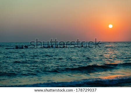 Dawn Surf-Ski Paddlers Ocean Sunrise Ocean surf-ski paddlers silhouetted in training at dawn sun rising in horizon sky