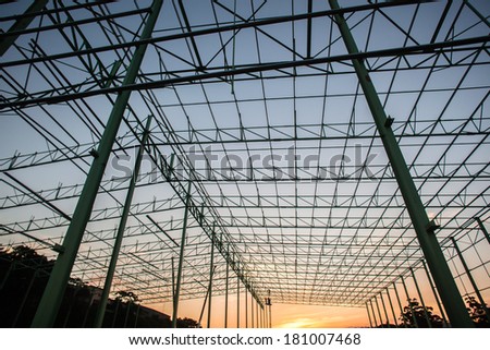 Construction Steel Frame Building Construction of steel frame building warehouse structure bolt nut secured welded  together piece by piece until fully complete enclosed structure.