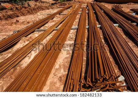 Steel Metal Rods Construction Steel metal rod lengths dozens lay stacked ready for construction into concrete structures for support strength.