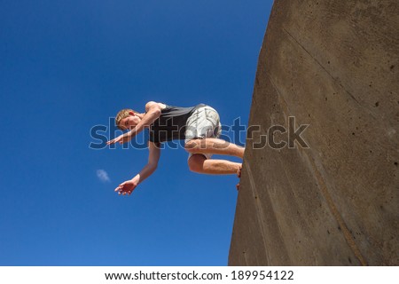 Teen Boy Jumping Park Hour Teen boy park hour jumping off wall into somersaults flips into blue sky on beach