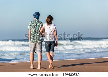 Teens Girl Boy Hanging Out  Beach Waves Teenagers boy girl morning hanging out social talk time walking together at beach with ocean waves.