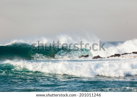 Ocean Wave Upright Crashing Rocks Blue ocean wave upright crashing breaking onto beach shallow reefs sandbars