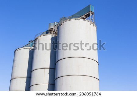 Grain Silos Blue Sky Three storage food grain metal silos against blue sky