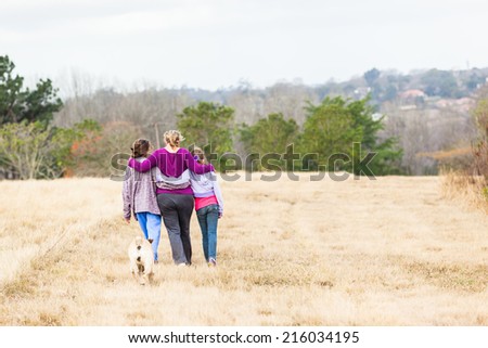 Girls Family Hugging Walking Outdoors Mother with teenage girls walking hugging in nature countryside landscape