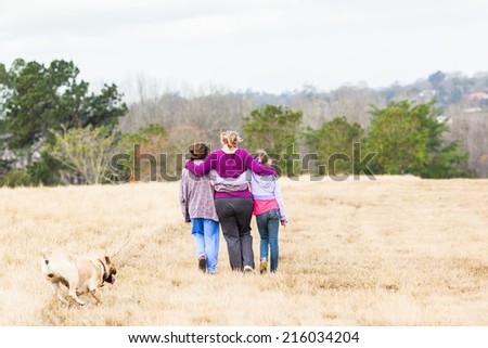 Girls Family Hugging Walking Outdoors Mother with teenage girls walking hugging in nature countryside landscape