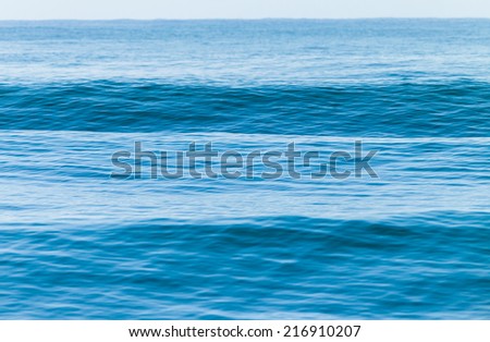 Blue Ocean Swells Blue ocean wave swells glass smooth water heading towards beach shallows