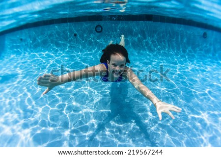 Girl Underwater Pool Summer Young girl swims smiles underwater in swimming  pool  playtime  summer