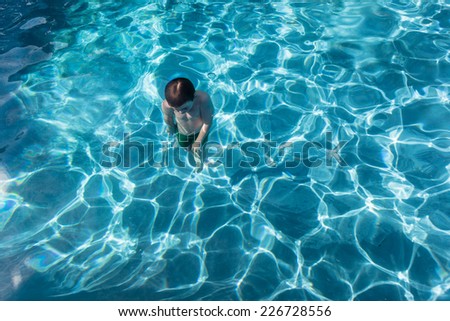 Boy Underwater Pool  Young boy swimming underwater in pool late afternoon summer days