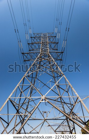 Electrical  Tower Cables Electrical high voltage power-lines tower metal structure attached cables in blue sky