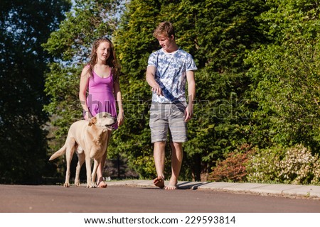Teen Boy Girl Walking Talking Dog Teenagers girls boy hangout summers day home talk laugh playtime walking with dogs