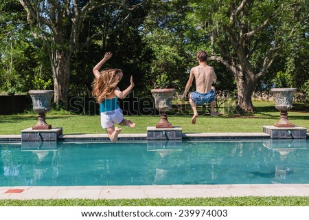 Boy Girl Jumping Pool Teenagers boy girl running  jumping into swimming pool home summer playtime