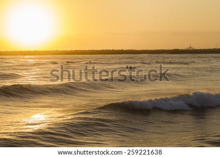 Surf-Ski Paddlers Ocean Sunrise\
Surf-ski paddlers at sunrise training on ocean waves waters around shallow reefs.