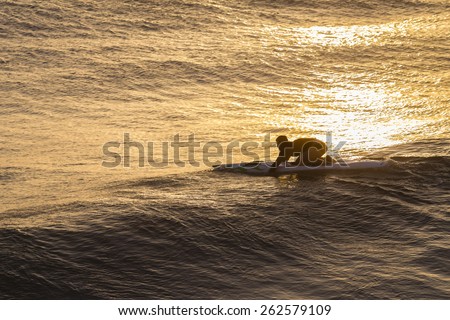 Lifeguard Rescue Craft Sunrise\
Lifeguard unidentified male athlete trains at sunrise on rescue craft paddling out through ocean wave swells.