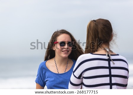 Girls Talking Beach\
Girls teenagers at beach holidays talk laughter socializing by beach ocean waves