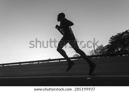 Marathon Runners Black White Durban - South Africa - 31 May - 2015. Comrades Marathon runners on the road action closeup dawn silhouettes .
