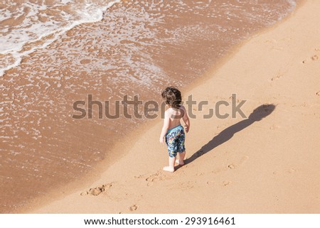 Child Beach Adventure Young boy child on beach ocean sands new explore adventure overhead photo.
