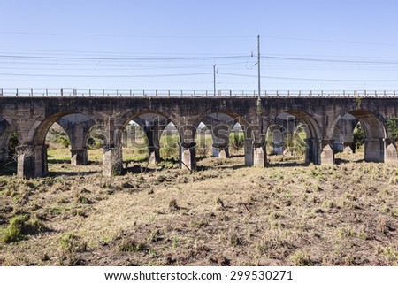 Train Railway Bridge Arches
Train railway bridge concrete arches two bridges over dry river bed landscape