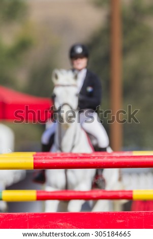 Equestrian Horse Rider Gate\
Equestrian horse rider blurred show jumping gates poles colors on arena course.