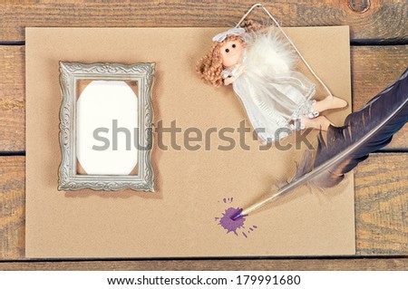 old paper, feather, angel, frame on a wooden table