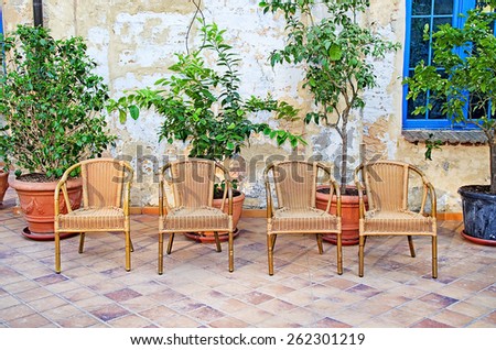 Beautiful porch courtyard decorated with flowers and wicker chairs. background models