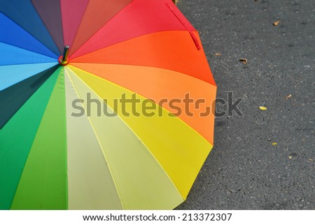 Umbrella with rainbow colors on the pavement