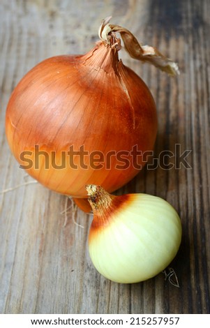 Big golden bulb onion on wooden table
