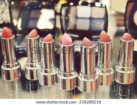 Set of colorful lipsticks with other cosmetics on a dressing table
