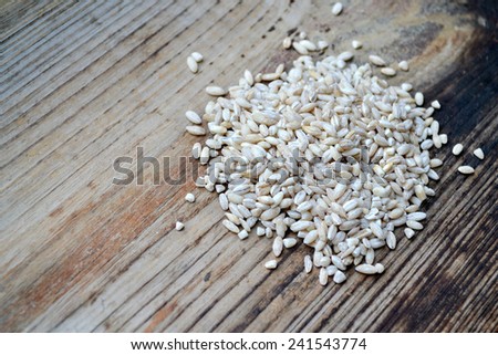 Pearl barley grains on wooden table