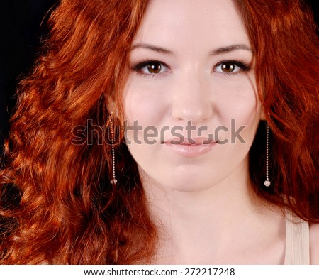 Beautiful young redhead woman with perfect daytime makeup and long silver earrings smiling